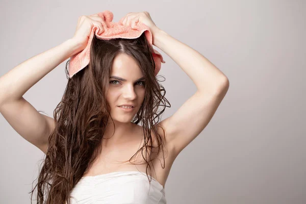 Young woman drying her hair with towel on light background — Stock Photo, Image