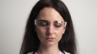 Koruyucu cerrahi maske takan bir kadın doktorun portresi.