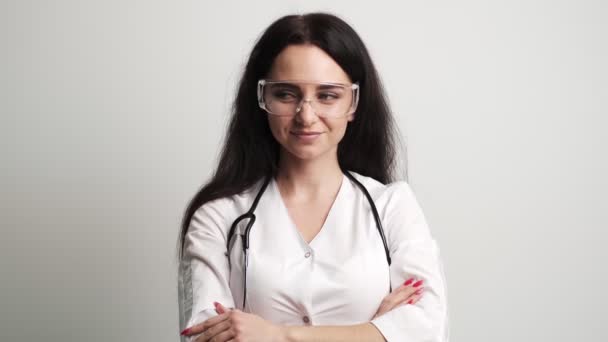 Femme médecin en lunettes et manteau blanc posant à la caméra — Video