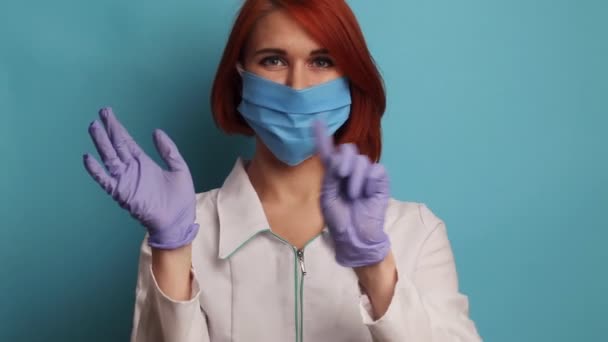 Enfermera joven muestra en video cómo quitar con seguridad el equipo de protección personal. — Vídeos de Stock