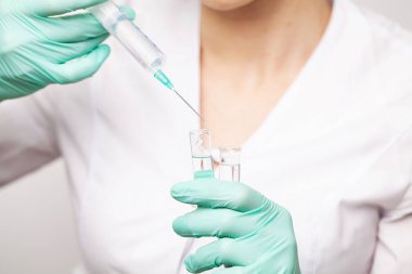 Şırıngayı dolduran doktorların elleri