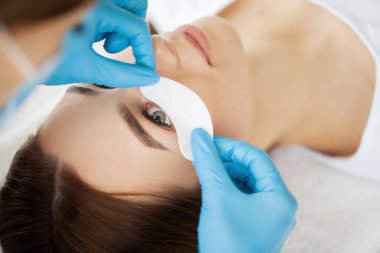 Kirpik Uzatma Prosedürü, kadın kirpiklerini uzatan profesyonel stilist.