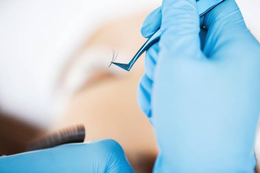 Kirpik Uzatma Prosedürü, kadın kirpiklerini uzatan profesyonel stilist.