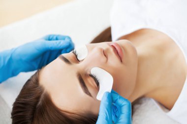 Kirpik Uzatma Prosedürü, kadın kirpiklerini uzatan profesyonel stilist.