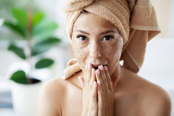 Young woman applying scrub on face in bathroom — Stock Photo, Image