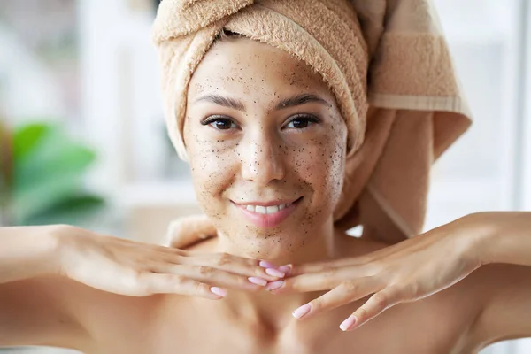 Cuidados com a pele, jovem mulher aplicando esfoliação no rosto no banheiro — Fotografia de Stock