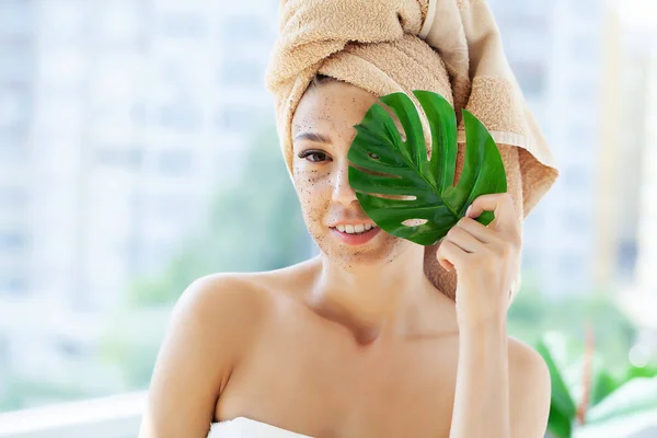 Young woman applying scrub on face in bathroom — Stock Photo, Image