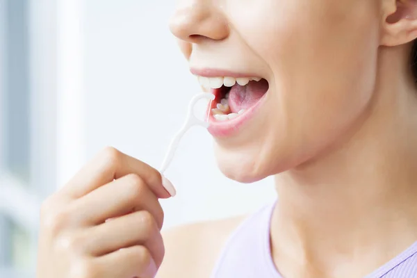 Retrato de mujer hermosa limpiando dientes con hilo dental — Foto de Stock