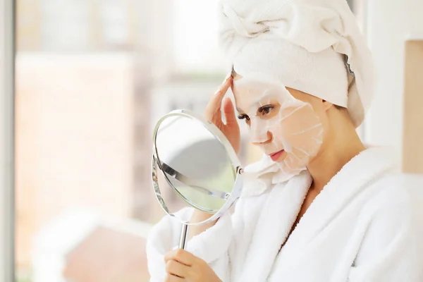 Hautpflege: Schöne Frau mit Gesichtsmaske im Schönheitssalon — Stockfoto