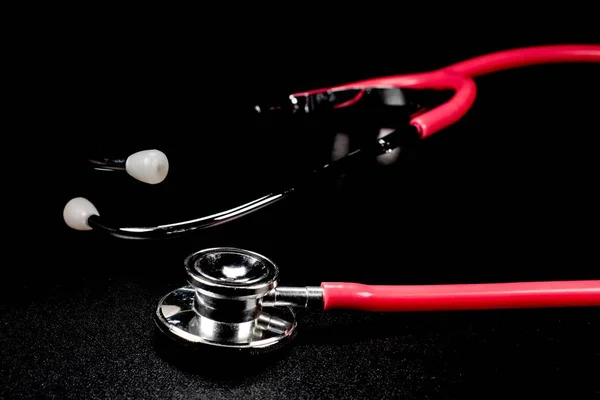 Stetoskopy są jednymi z najważniejszych narzędzi pielęgniarki lub lekarza na czarnym tle — Zdjęcie stockowe