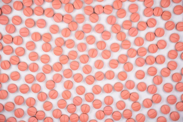 Comprimidos redondos de cor laranja sobre fundo branco com foco seletivo. Comprimidos que parecem ecstasy — Fotografia de Stock