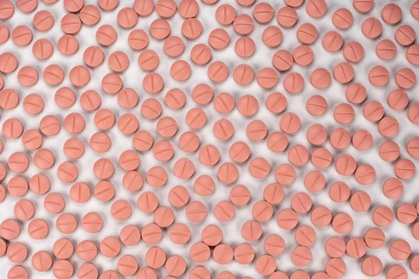 Pillole rotonde di colore arancione su sfondo bianco con messa a fuoco selettiva. Pillole che sembrano estasi — Foto Stock