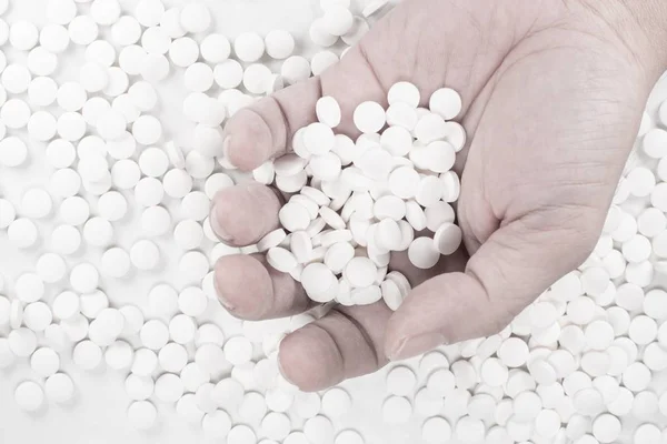 Suicide Pills, Pills, tablets in dead man 's hand by overdosing on medicine. Vista superior de cerca de las píldoras de sobredosis sobre fondo blanco . — Foto de Stock