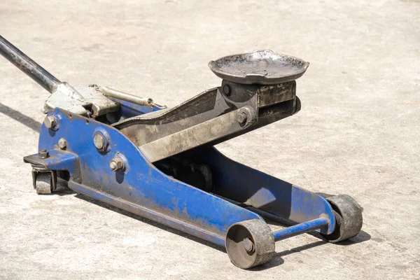 Jack ou levage de véhicule hydraulique usagé pour l'inspection de la carrosserie du véhicule, les réparations des freins . — Photo