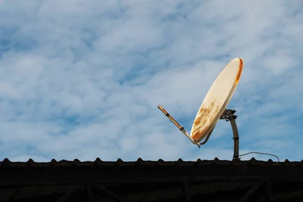 Roto y viejo antena parabólica en el techo y el fondo del cielo azul . —  Fotos de Stock