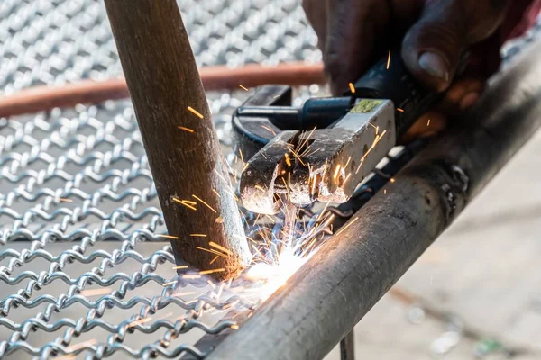 Işçi kuş kafesi yapmak için elektrikli kaynak tel örgü kullanılır. — Stok fotoğraf