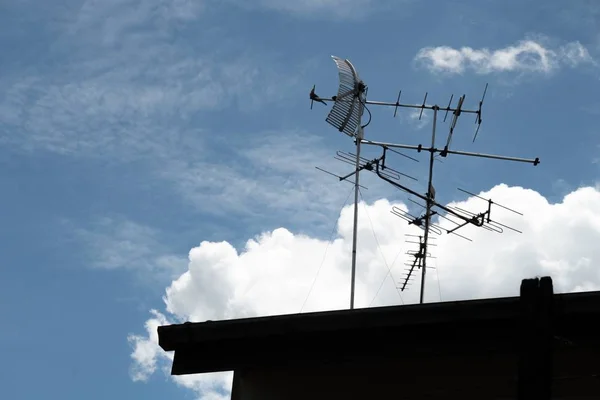 Antena de televisão analógica no topo do telhado velho com pombo e fundo céu azul — Fotografia de Stock