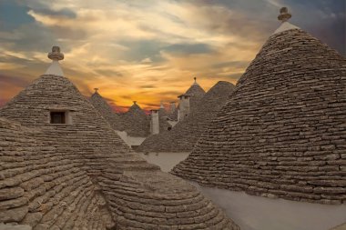 Günbatımında Alberobello 'daki Trulli' nin çatıları, Apulia, İtalya. Alberobello İtalya 'nın güneyinde küçük bir kasabadır. Trullo, konik çatısı olan geleneksel bir Apulian kuru taş kulübesi..
