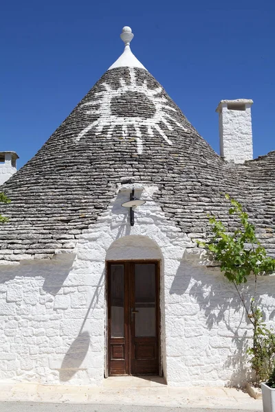 意大利阿普利亚阿尔伯罗韦略大街的屋顶上印有图鲁洛标志 阿尔韦诺韦略是意大利南部的一个小镇 滑铁卢是一种传统的阿普利亚干石屋 屋顶呈锥形 — 图库照片