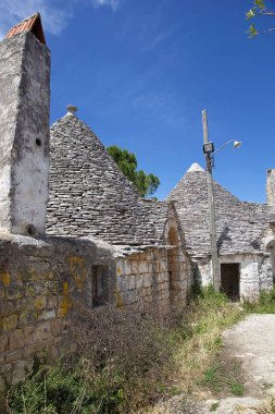 Trulli cadde boyunca Alberobello, Apulia, İtalya 'da. Alberobello İtalya 'nın güneyinde küçük bir kasabadır. Trullo, konik çatısı olan geleneksel bir Apulian kuru taş kulübesi..