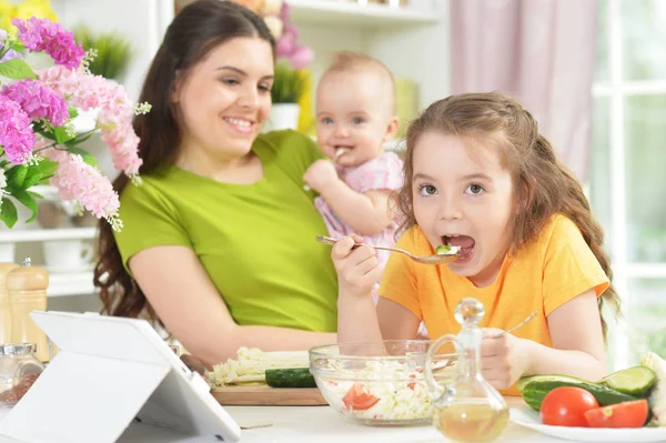 Linda Niña Comiendo Ensalada Fresca Mesa Cocina Con Tableta Ella —  Fotos de Stock