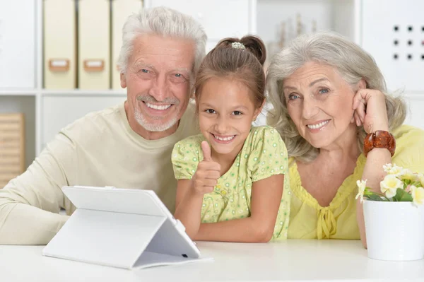 祖父母与她的孙女在家里使用片剂 — 图库照片
