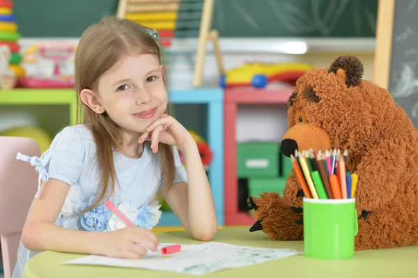 可爱的女学生坐在桌子和图画 — 图库照片