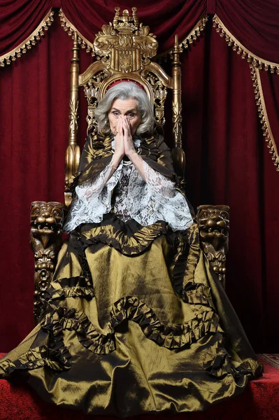 美丽的高级女皇后在王位上 — 图库照片