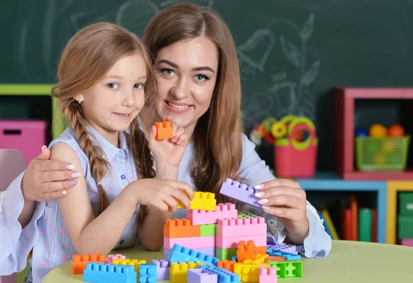 Matka a dcera hrát s plastovými bloky — Stock fotografie