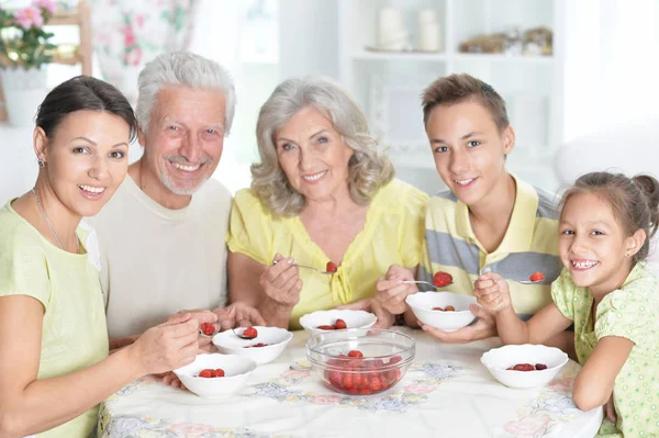 キッチンで新鮮なイチゴを食べて幸せな大家族 — ストック写真
