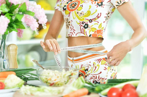 Ung kvinna förbereder sallad — Stockfoto