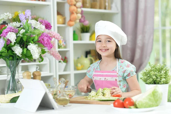 Симпатична Маленька Дівчинка Ріже Капусту Кухонному Столі Планшетом Вдома — стокове фото