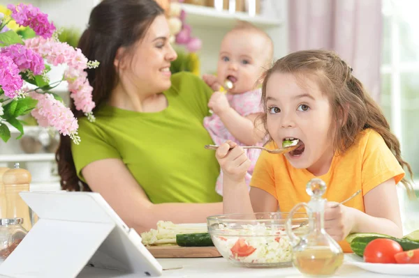 Schattig Klein Meisje Frisse Salade Eten Aan Keukentafel Met Tablet — Stockfoto