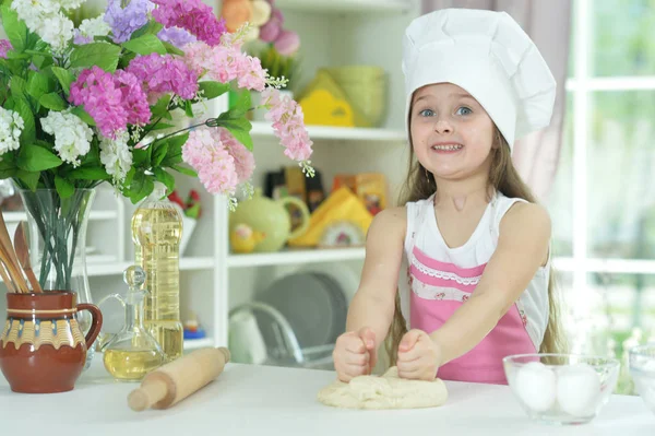 可爱的女孩在厨师帽子做面团在厨房在家 — 图库照片