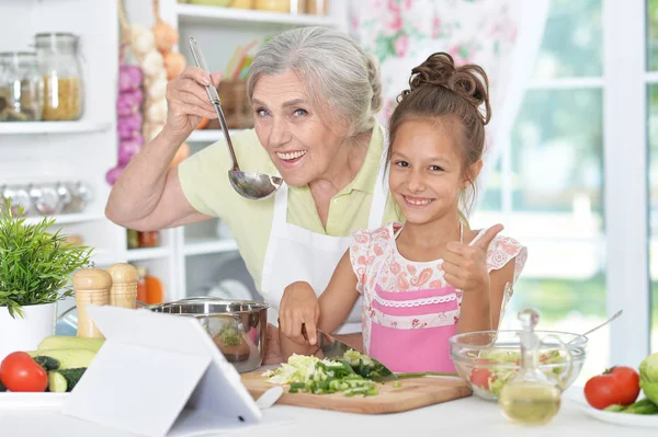 Mormor och barnbarn förbereder middag — Stockfoto