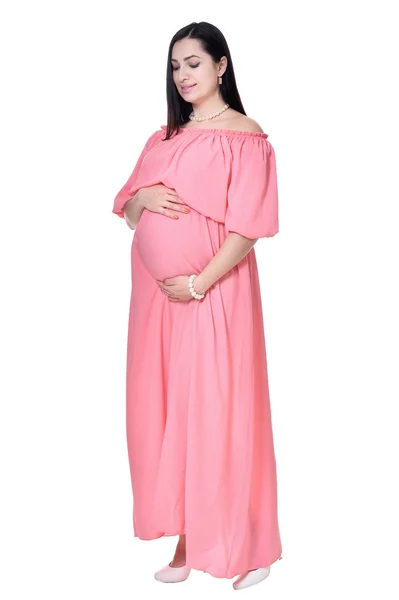 美丽的孕妇在粉红色的礼服假扮白色背景 — 图库照片