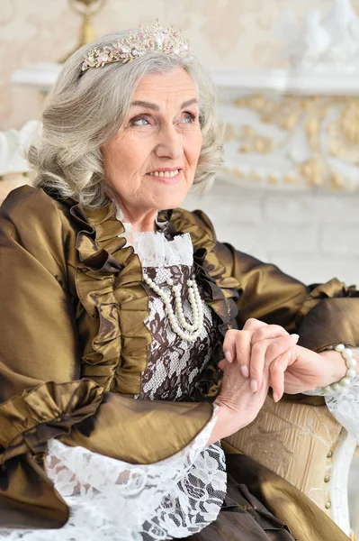 Senior woman sitting in vintage chair — Stock Photo, Image