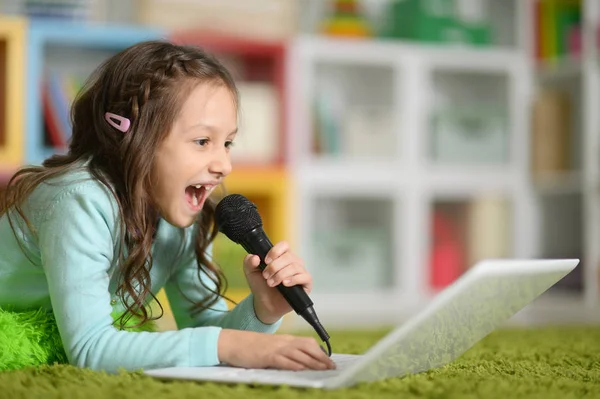 Χαριτωμένο Κορίτσι Τραγουδώντας Καραόκε Φορητού Υπολογιστή Ενώ Βρίσκεται Στον Όροφο — Φωτογραφία Αρχείου