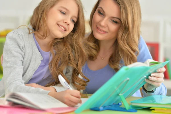 Мати з дочкою робить домашнє завдання — стокове фото