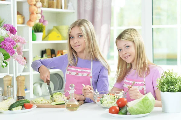 Dvě Dívky Růžové Zástěry Připravuje Čerstvý Salát Kuchyňském Stole — Stock fotografie