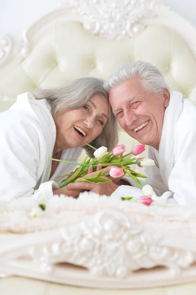 Senior man gives flowers to a woman — Stock Photo, Image