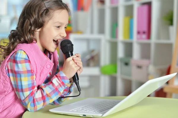 Menina Bonito Cantando Karaoke Com Laptop Enquanto Sentado Mesa — Fotografia de Stock