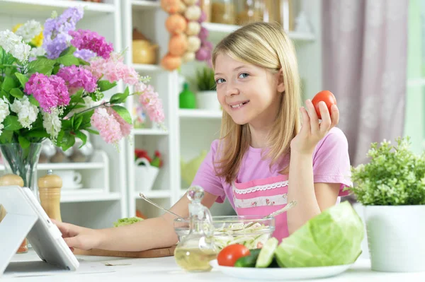 Menina Bonito Segurando Tomate Enquanto Prepara Salada Fresca Mesa Cozinha — Fotografia de Stock