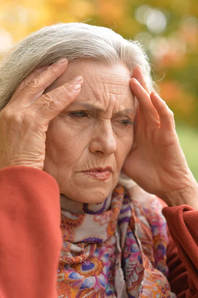 公园里有头痛的老年妇女画像 — 图库照片