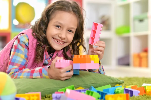 Yerde Yatarken Renkli Plastik Bloklarla Oynama Kıvırcık Kız — Stok fotoğraf