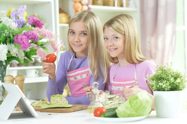 Two Girls Pink Aprons Preparing Fresh Salad Kitchen Table Tablet — Stock Photo, Image