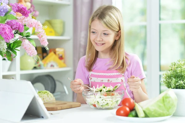 Nettes Kleines Mädchen Schaut Auf Tablet Während Frischen Salat Auf — Stockfoto