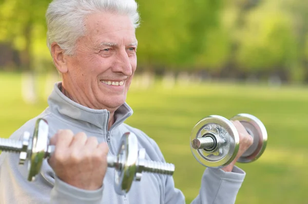 Anciano haciendo ejercicio con pesas — Foto de Stock