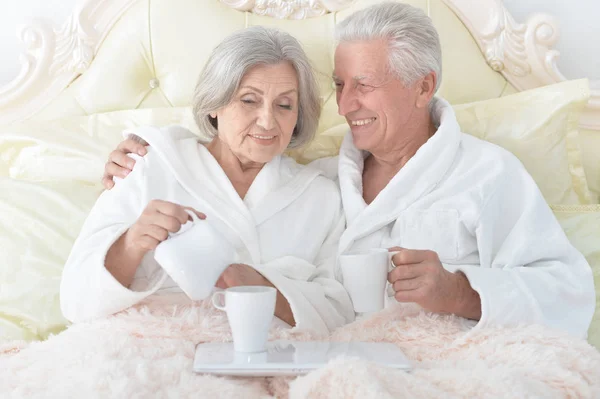 Senior echtpaar in bed met thee — Stockfoto