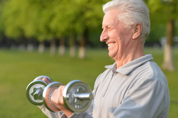 Anciano haciendo ejercicio con pesas — Foto de Stock